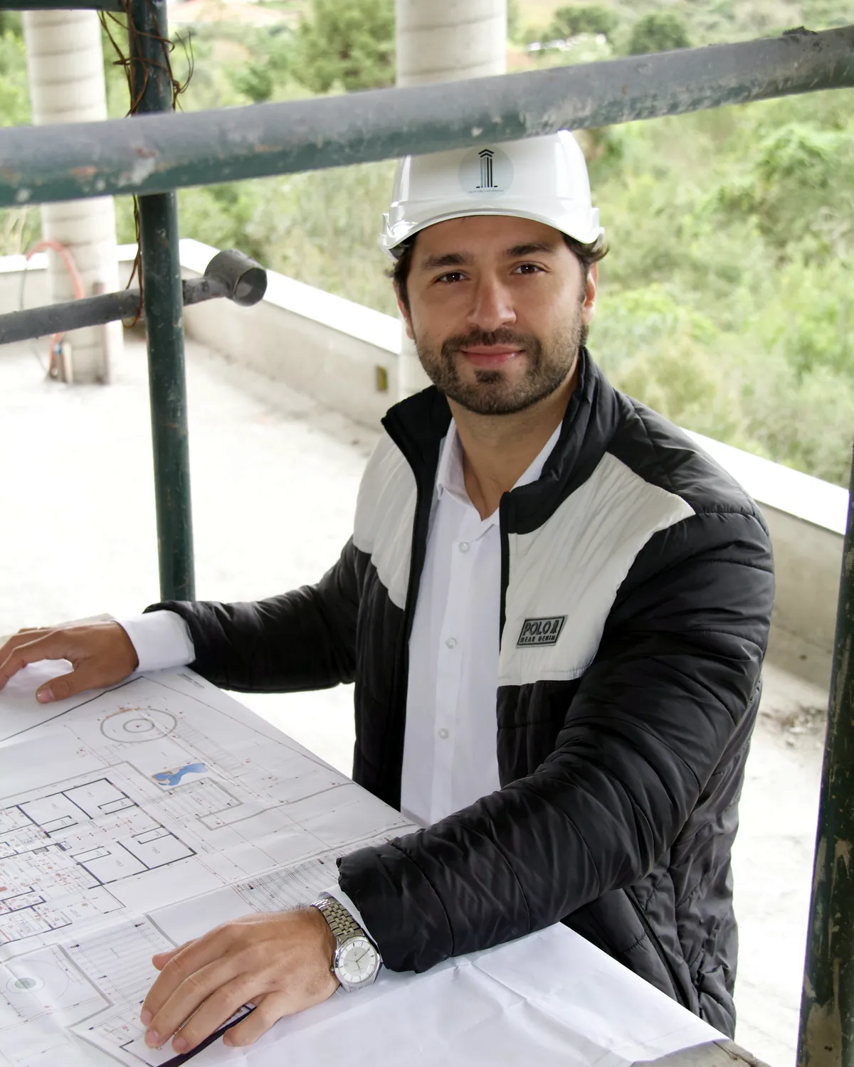 Rafael Ribeiro Silvestre revisando a planta sobre a laje da obra